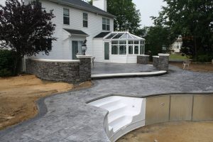stamped-concrete-pool-patio-gray-retaining-walls